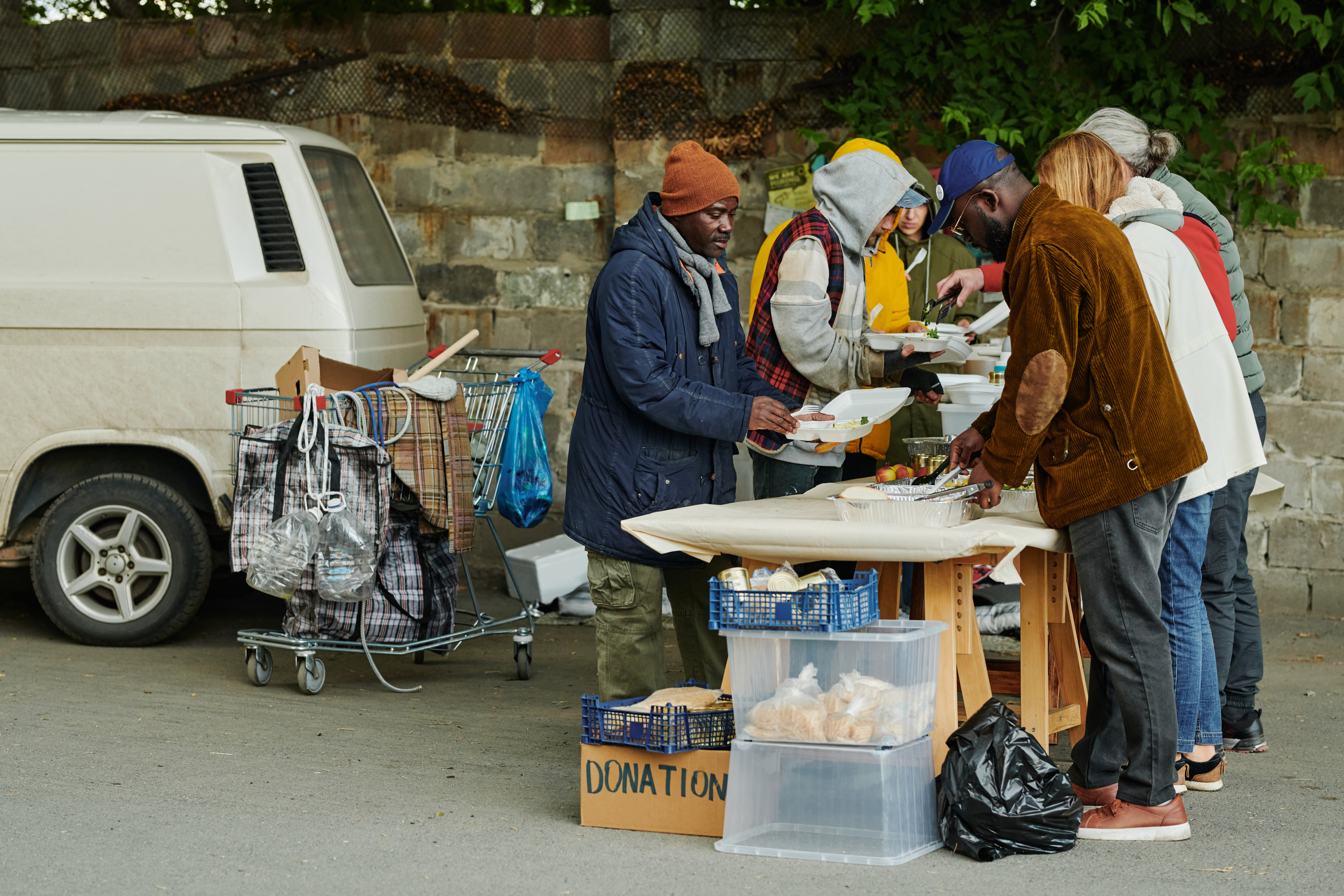Unhoused persons gather round a table